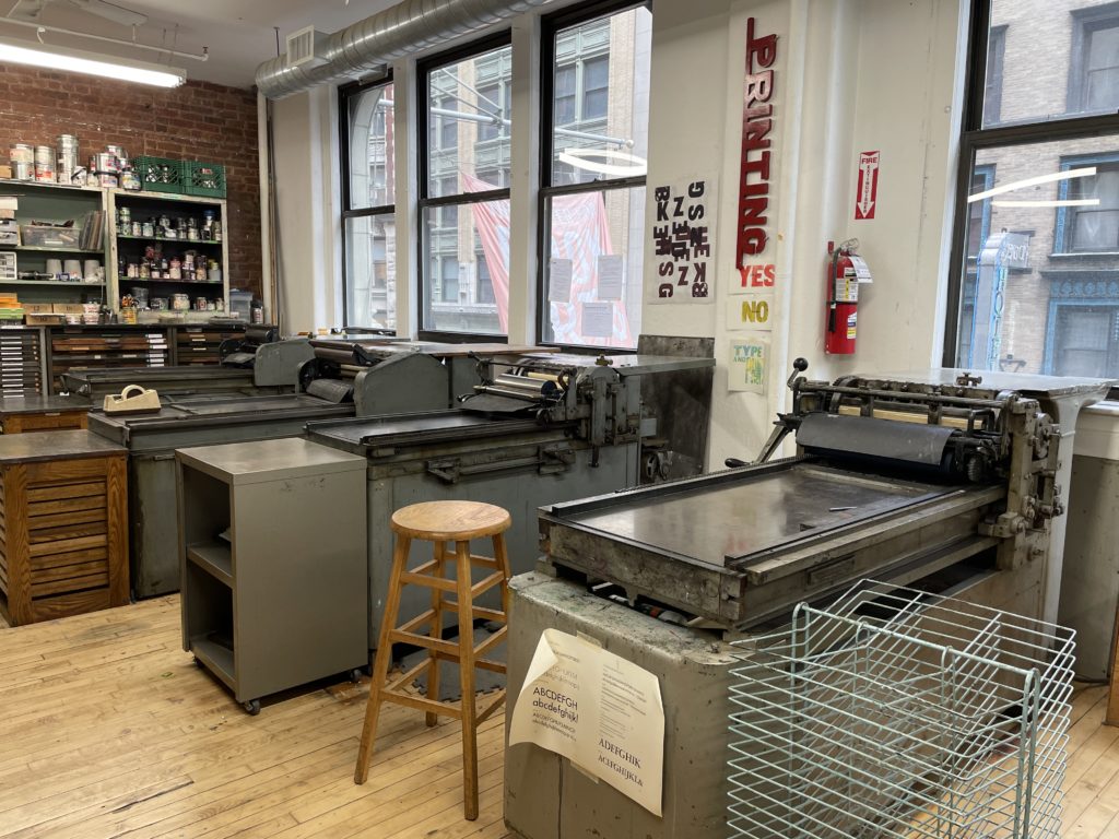 printshop filled with movable type and multiple vandercook letterpresses