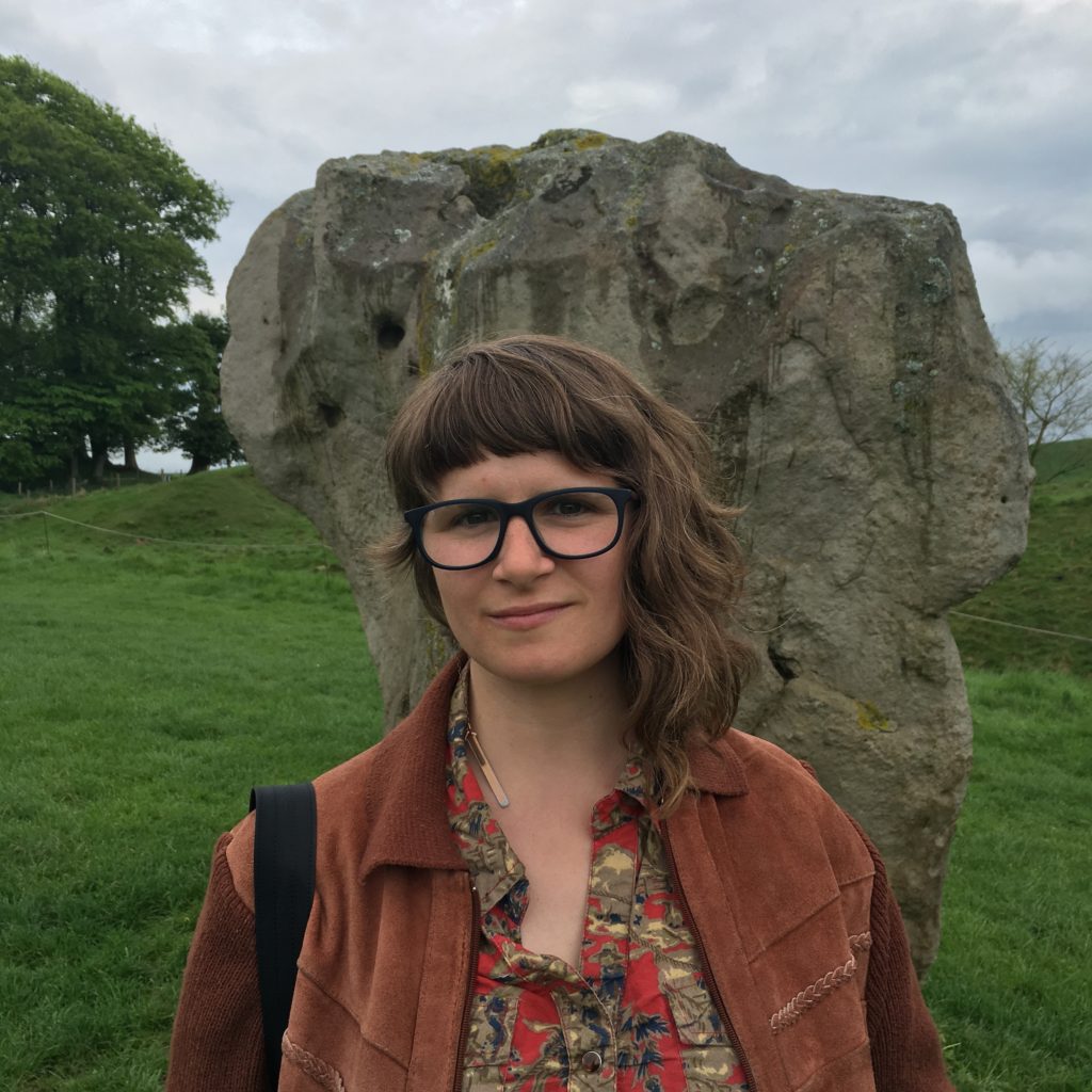 fair skin woman with asymmetrical brown hair and glasses